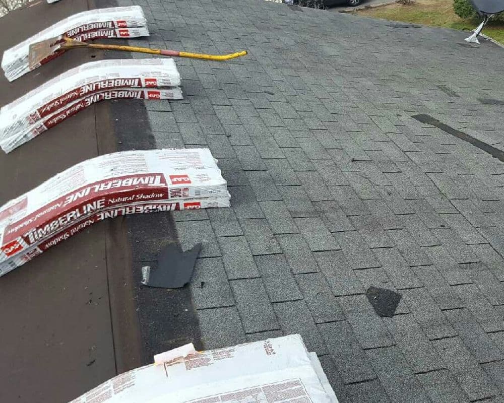 Roofing shingles stacked neatly on a sloped roof, ready for installation.