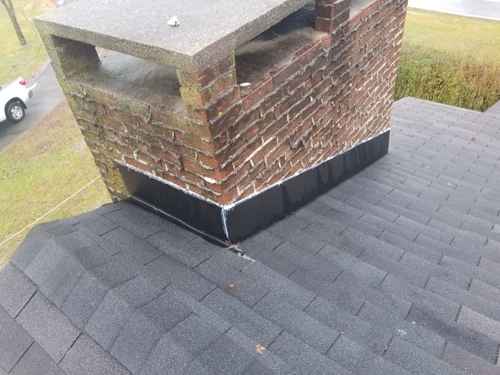 Chimney on a pitched roof, with visible shingles and flashing details.